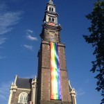 Westertoren with rainbow flag alongside against a blue sky