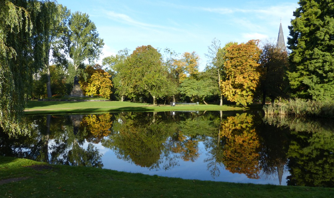 View over a pond reflecting the autumnal coloured trees on the other side