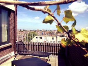 Part of a balcony with lounge chair and a view over Amsterdam West