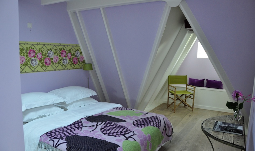 One of the bedrooms, with light purple walls and a bed