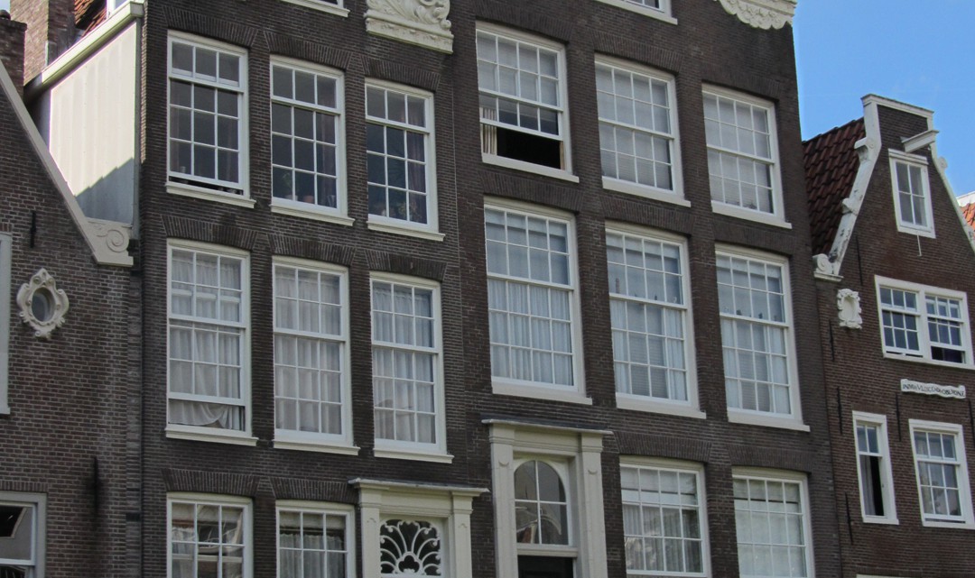 Two typical Amsterdam gable houses with many windows that are divided in smaller square glass