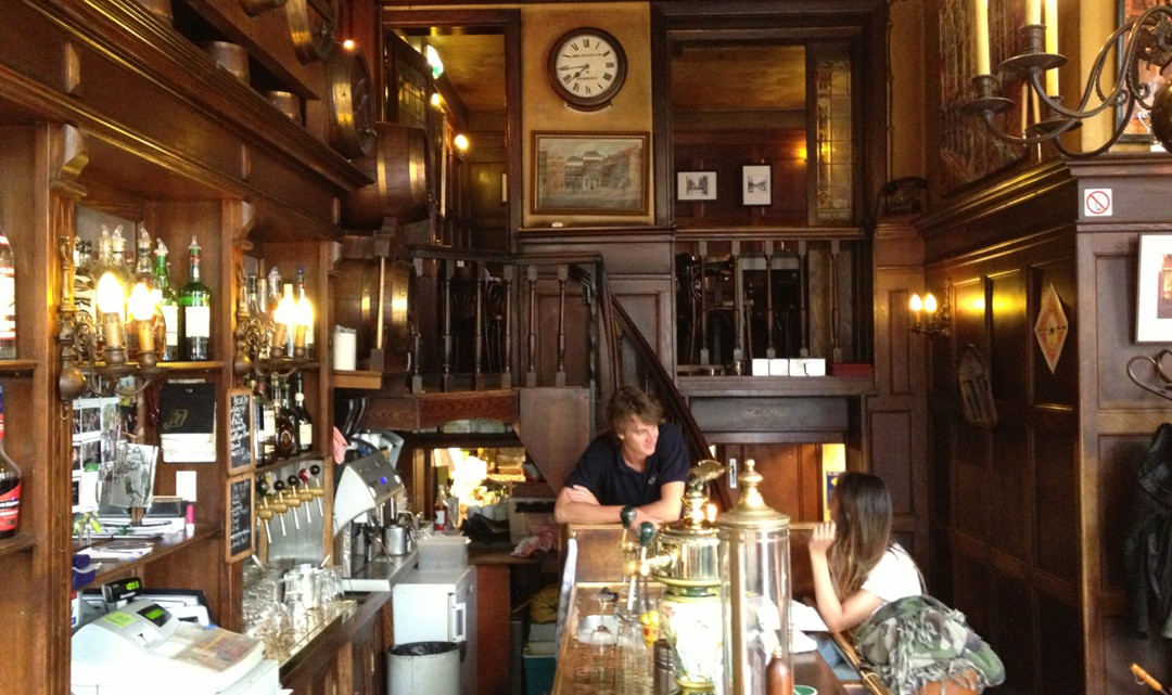 A view behind the bar with lots of wood paneling and original features