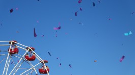 Quarter of a ferris wheel with confetti streamers flying through the air