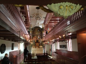 A view into the narrow church towards the altar and up to the balconies that are going around three sides