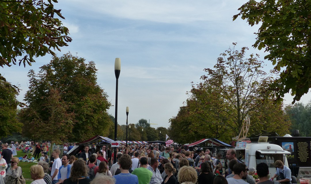 Many people strowling alongside the market stalls