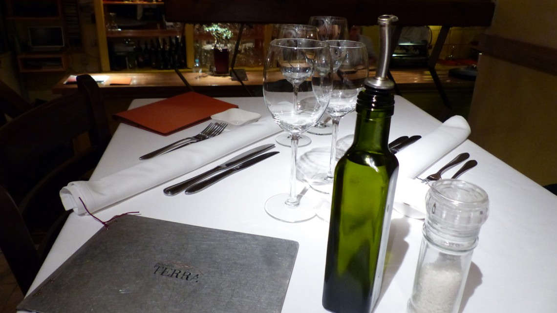 A set table with glasses, olive oil and the menu