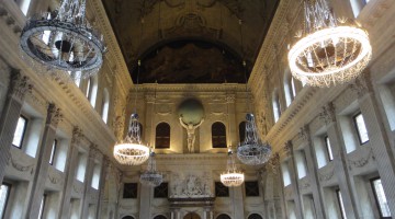 A view towards the chandeliers, the impressive statue of Atlas and the richly decorated windows and support columns