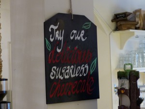 A blackboard sign with the text: Try our delicious cheesecake