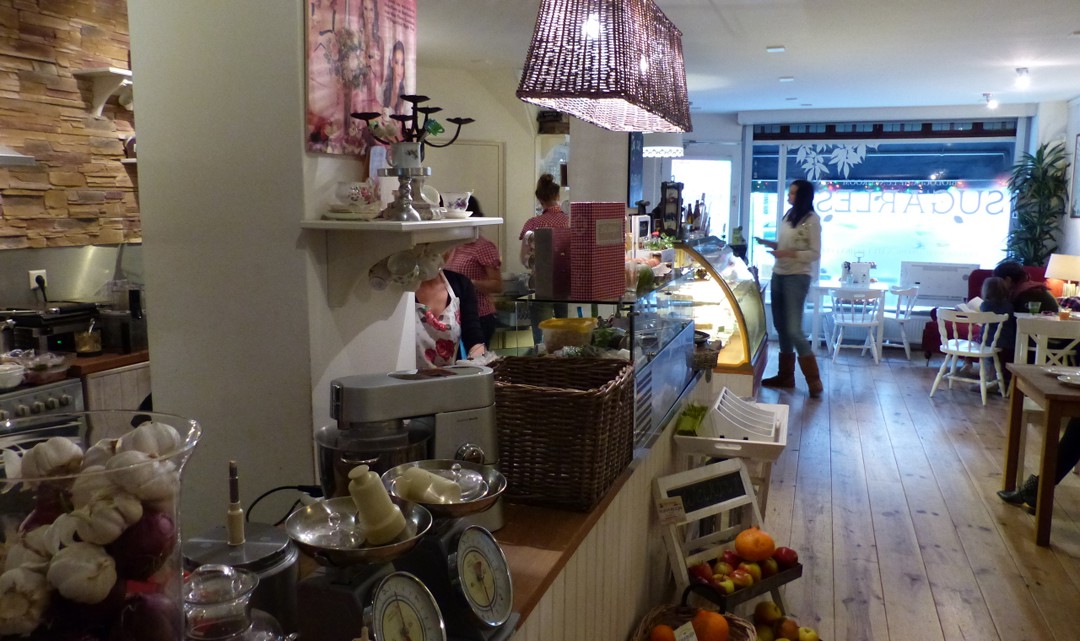A view of the interior towards the front door. On and in front of the counter there are many organic vegetables and other ingredients displayed