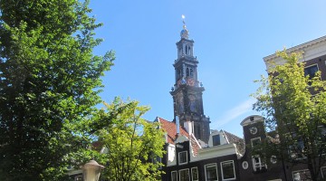 The church tower peeping out above Amsterdam canal houses