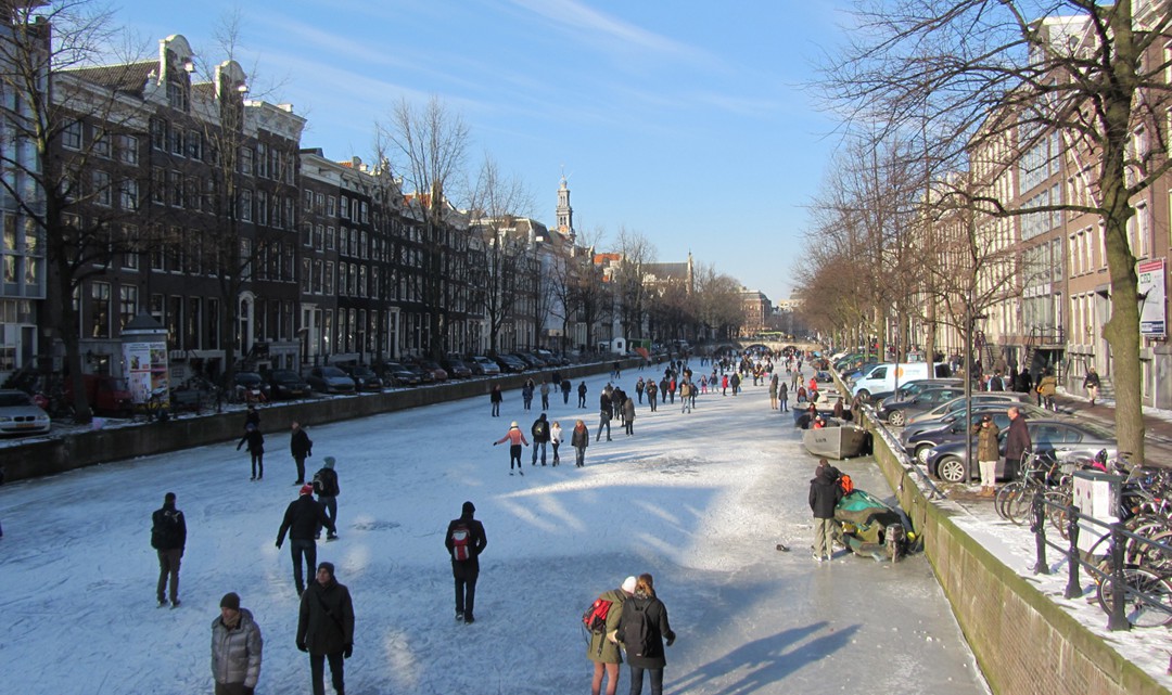 People ice skating on the Keizersgracht on a sunny day